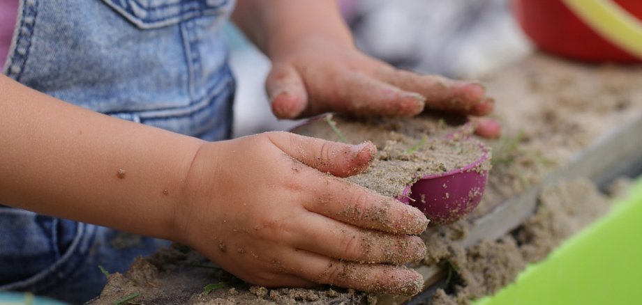 Kindergartenkind beim Spielen mit Matsch und Förmchen