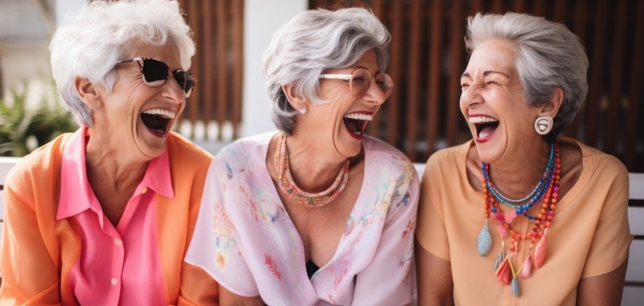 Drei ältere Frauen, die herzhaft lachen
