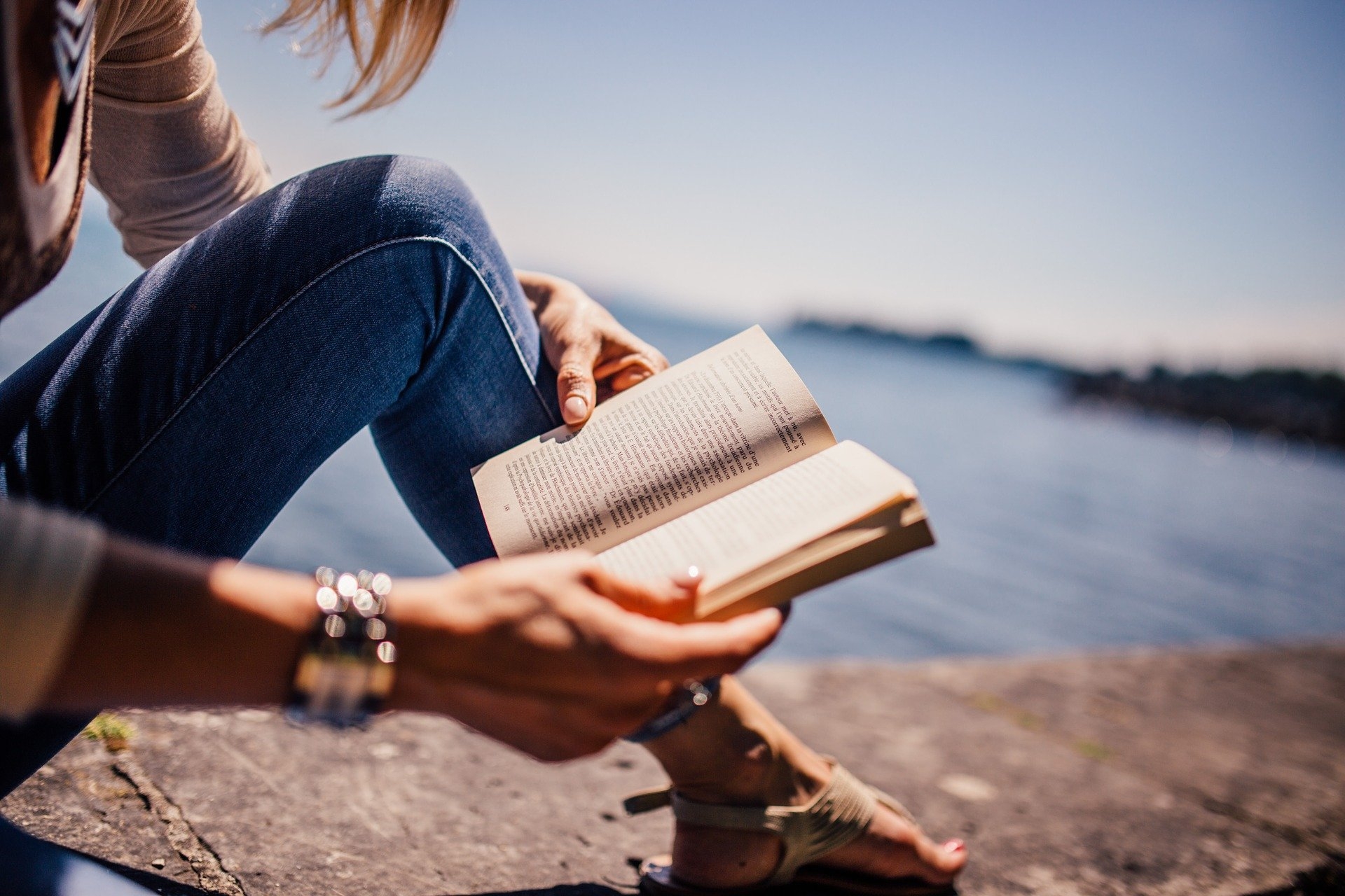 Frau sitzt am See und liest Frau sitzt am See und liest