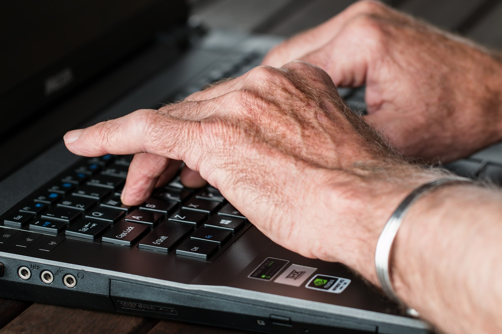 Seniorenhände auf Computertastatur Seniorenhände auf Computertastatur