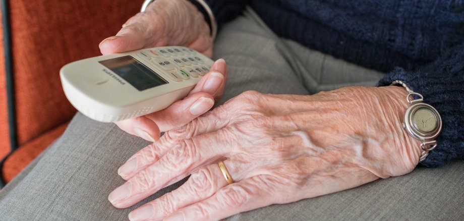 Alte Frau mit Telefon in der Hand