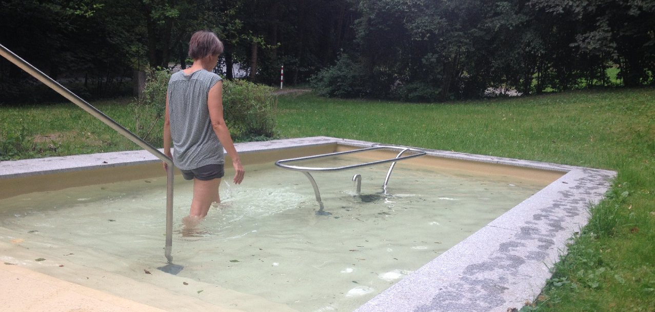 Frau beim Kneippen im Wassertretbecken