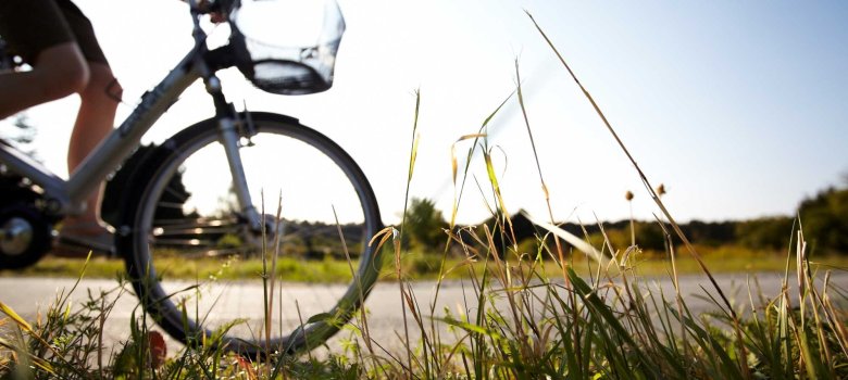 Frau beim Fahrradfahren am Feldrand