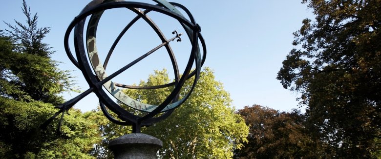 Sonnenuhr im Park mit Bäumen