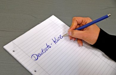 Schulheft mit schreibender Hand Schulheft mit schreibender Hand