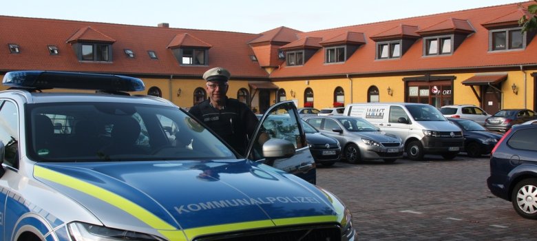 Polizist vorm Auto